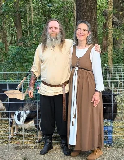 Shawn and Abby of Happy Little Hooves Farm standing together with their goats